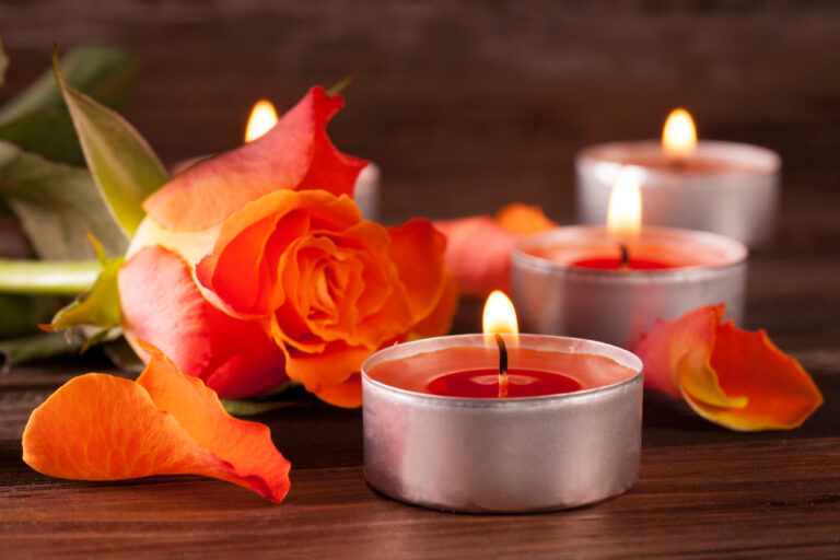 A closeup shot of lit red Christmas candles on a wooden surface