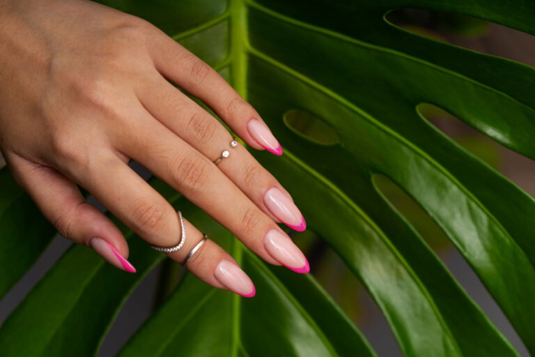 woman-showing-her-nail-art-fingernails-against-monster-leaf
